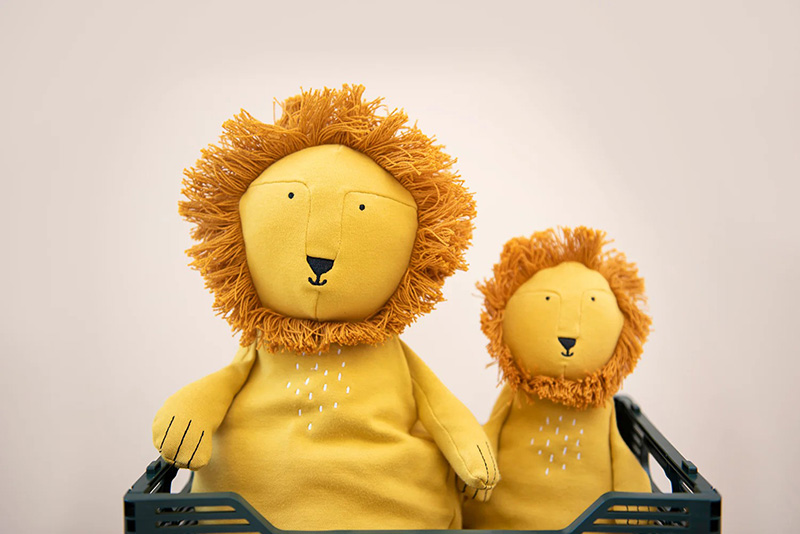Two lion plush toys sitting together in crate
