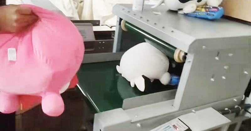 Plush toys pass through metal detection to ensure product safety and compliance before shipment.