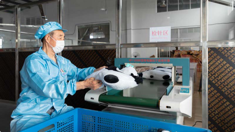 Plush toys pass through needle detection to ensure safety and compliance before shipment.