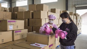 Factory staff inspect finished plush toys before packing to ensure consistent quality and compliance with approved standards.