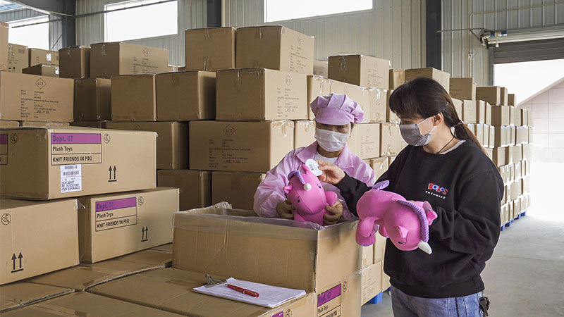 Factory staff inspect finished plush toys before packing to ensure consistent quality and compliance with approved standards.