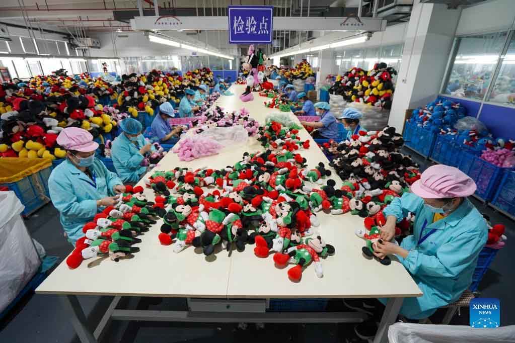 Workers conduct final checks on plush toys to ensure quality consistency before packing and shipment.