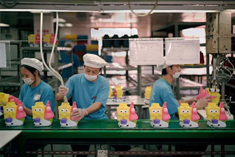 Workers assemble plush toys on a production line to ensure efficiency and consistent quality.