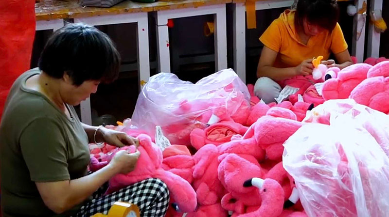Workers carefully hand-sew and finish plush toys to ensure clean seams and consistent quality.