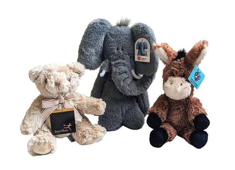 Three plush animals on a white background—a teddy bear, gray elephant, and brown donkey—each with a hanging brand tag.