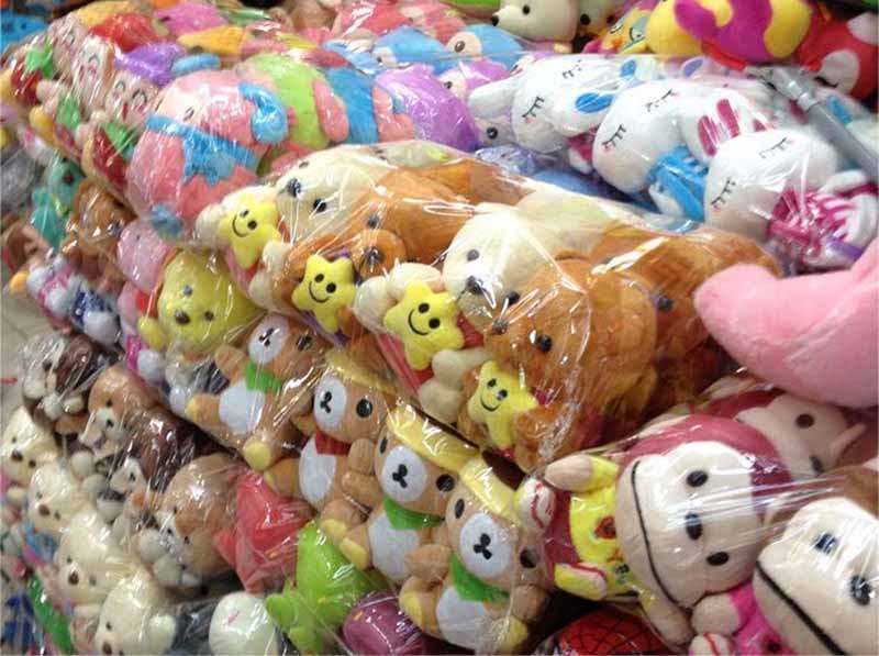 Large quantities of plush toys are packed in protective plastic, prepared for bulk storage and export shipping.