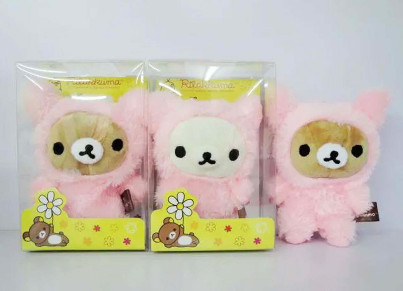 Three pink bear plush toys in individual clear display boxes, two boxed and one unboxed on a white background.