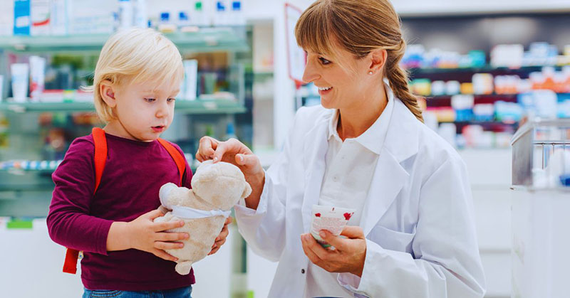 A staff member checks a plush toy with a child, highlighting product safety and consumer trust.