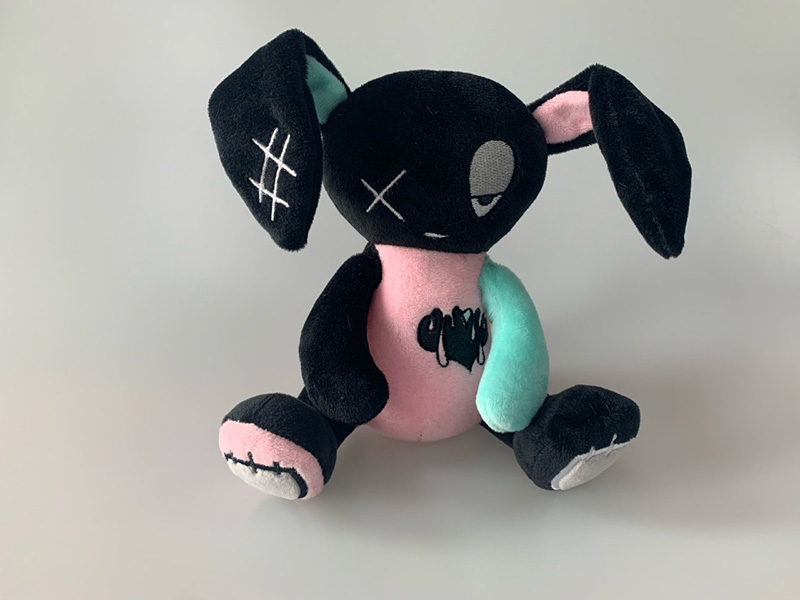 A uniquely styled plush toy featuring contrasting colors and embroidered details for a distinctive character look.