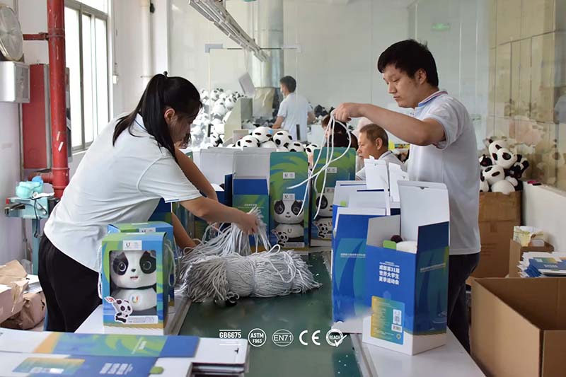 Workers prepare plush toys and packaging materials to ensure proper packing and compliance with international safety standards.