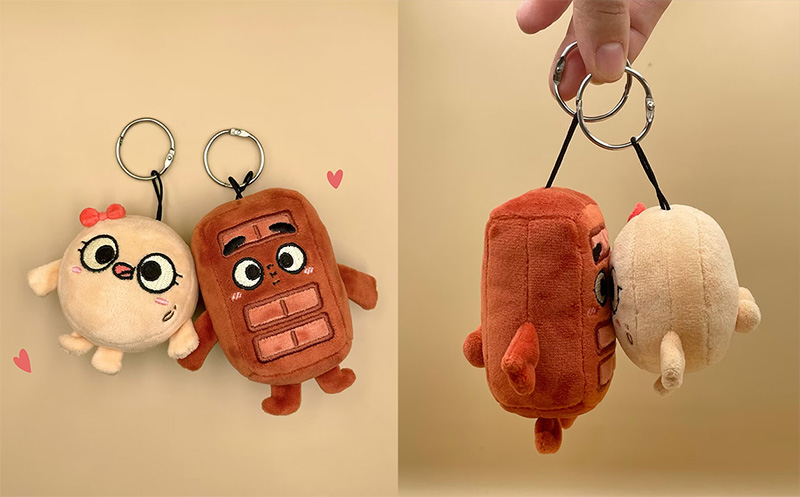 Two small plush keychains with embroidered facial details and metal rings, designed for bag charms and promotional use.