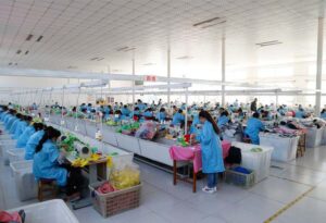 A full plush toy production floor with organized sewing lines and skilled workers, demonstrating stable capacity for large-volume orders and efficient manufacturing management.