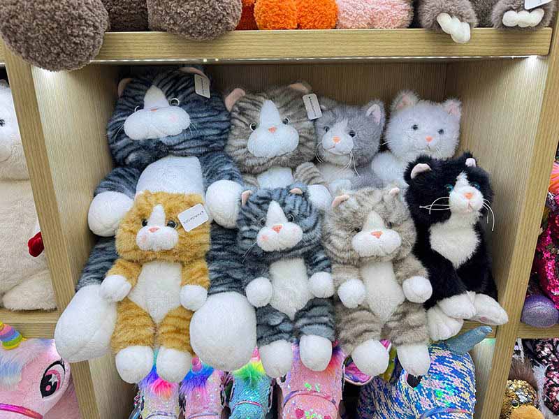 A collection of cat plush toys in various colors and sizes, displayed to showcase design variety and consistency.