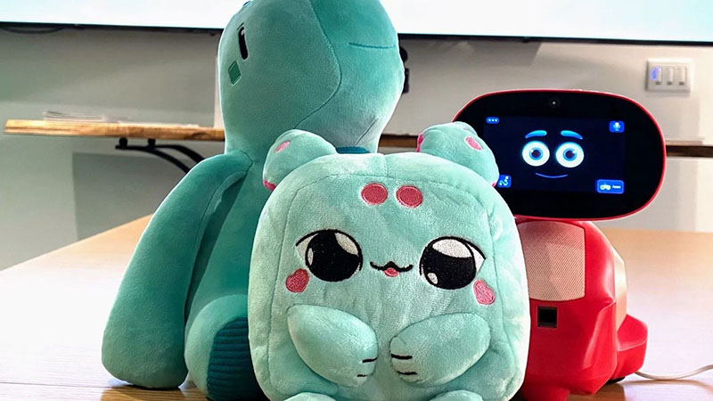 Interactive robot displayed alongside soft plush companions, showcasing the blend of technology and cuddly design for modern play experiences.