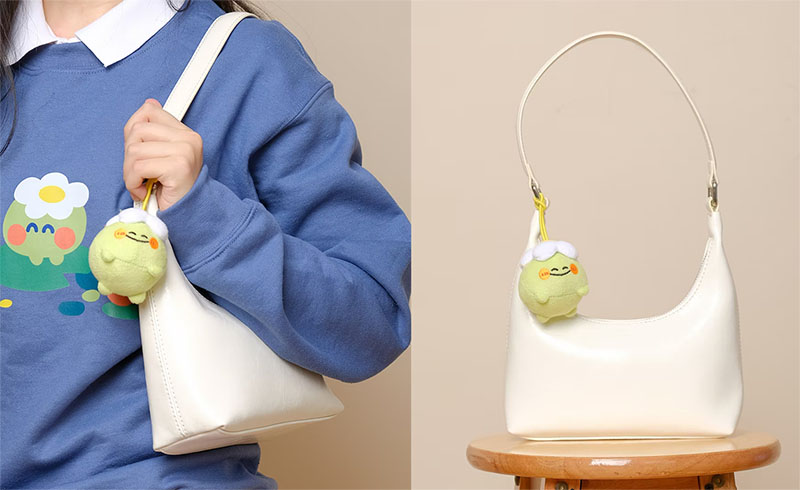 A small plush charm attached to a handbag, designed as a cute accessory for everyday fashion styling and brand merchandising.