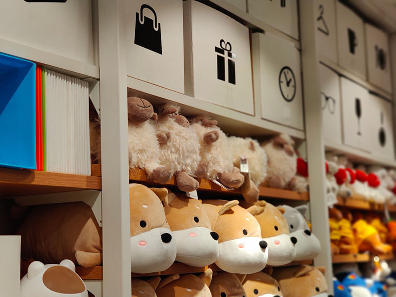 Neatly arranged plush toys on modern store shelves, highlighting organized merchandising and attractive product presentation.