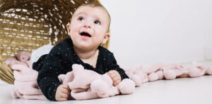 A baby enjoying a soft plush blanket, highlighting comfort, safety, and gentle materials suitable for infants.