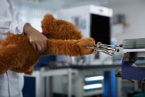 Quality control process showing mechanical pull-strength testing on a plush toy to ensure durability and safety compliance.