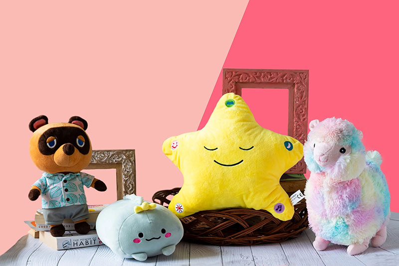 Assorted plush toys including animal and star designs, arranged for product showcase and branding display.