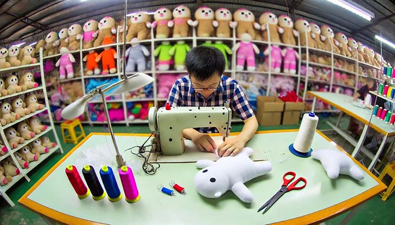 A technician sews a plush toy prototype, highlighting craftsmanship and attention to detail in custom plush development.