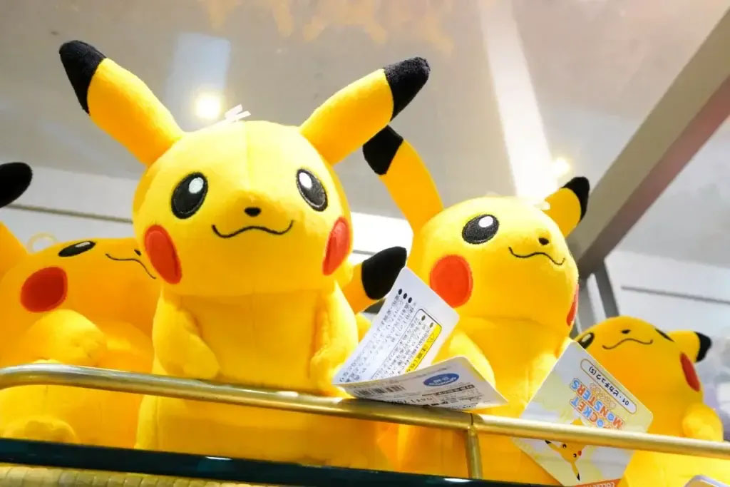 Bright yellow licensed character plush toys displayed on a store shelf, featuring embroidered facial details and official product tags for retail sale.