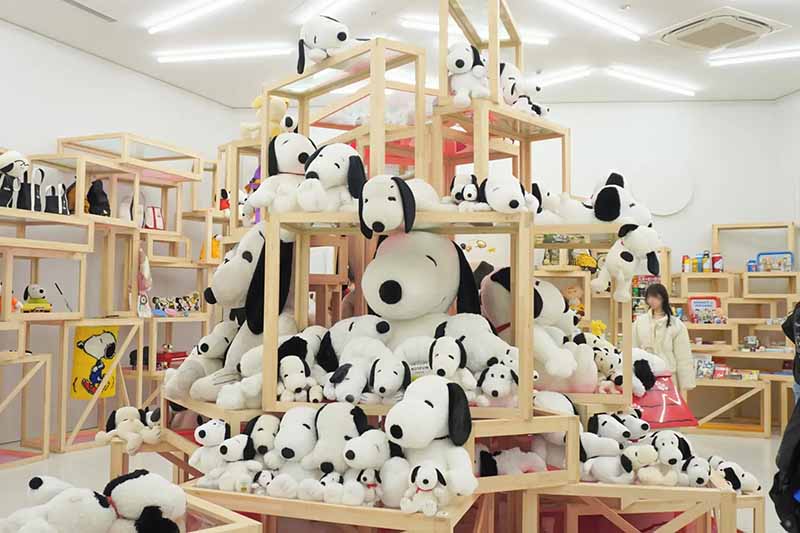A retail space filled with numerous plush toys arranged on wooden display shelves, creating an eye-catching and playful shopping environment.