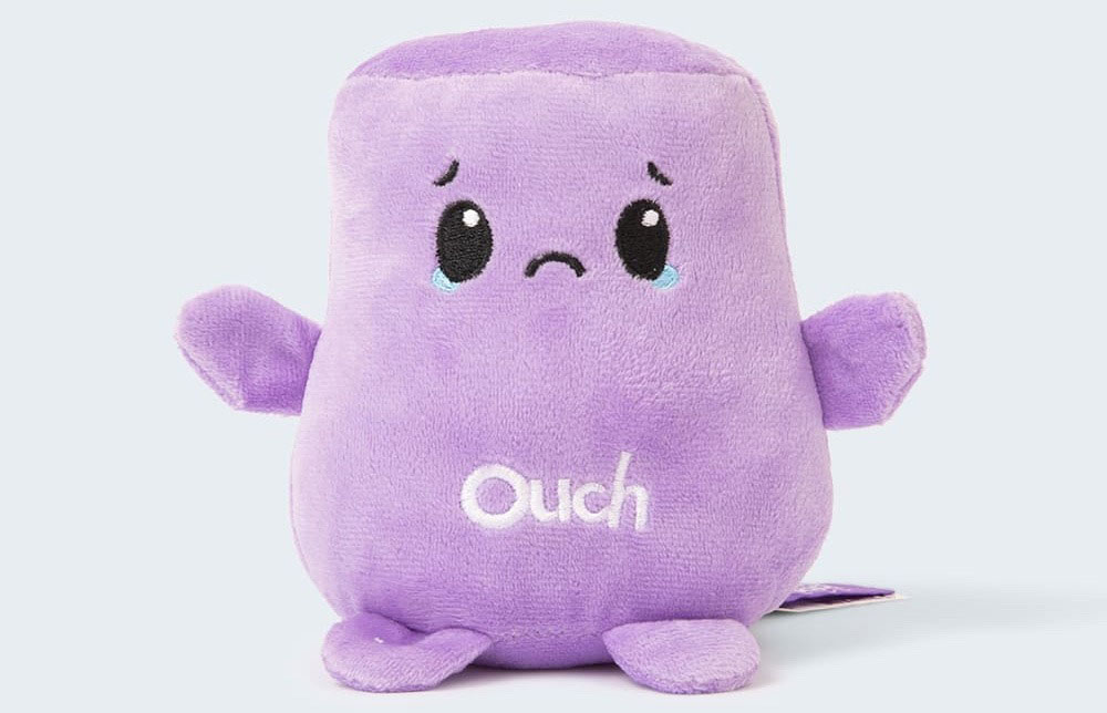 A small purple plush toy with a sad facial expression and embroidered “Ouch” text, designed to represent emotions and provide comfort or playful emotional communication.