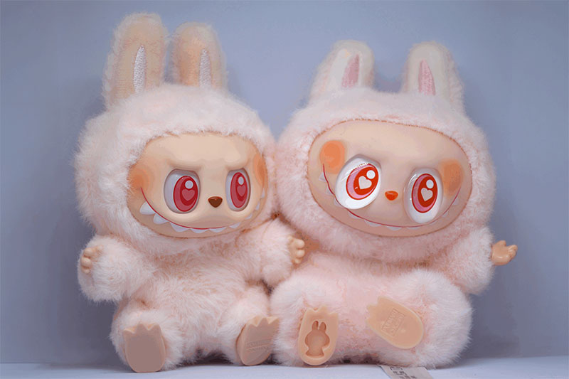 Two fluffy bunny-themed character plush dolls with large expressive eyes and soft fur texture, showcasing collectible designer toy styling.