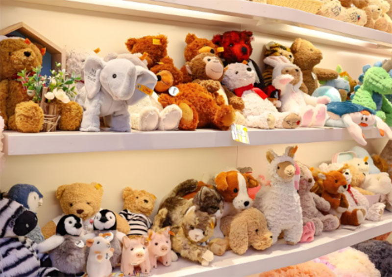 Assorted animal plush toys arranged on store shelves, showcasing a wide variety of styles, sizes, and designs available for retail sale.