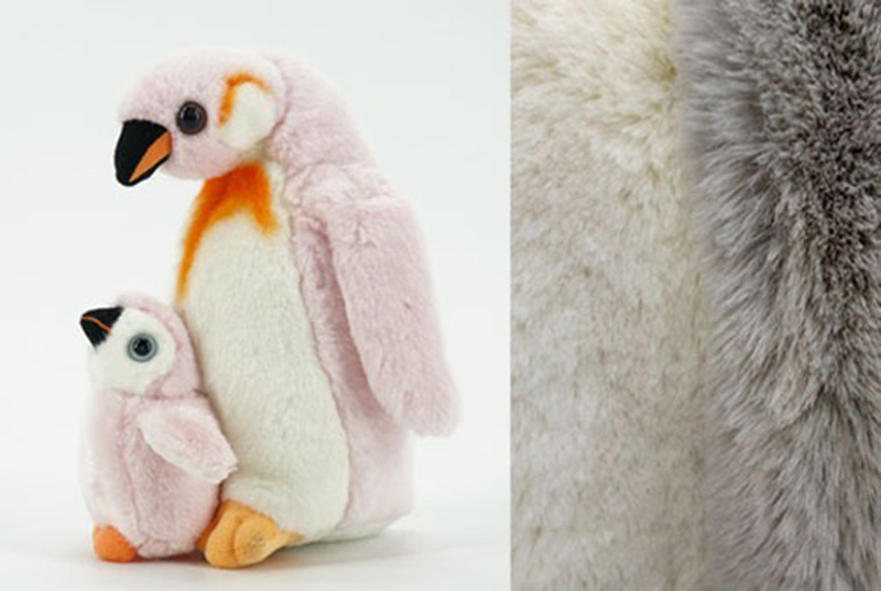 A realistic penguin plush toy with a baby penguin, featuring soft fur texture and detailed design inspired by real animals.