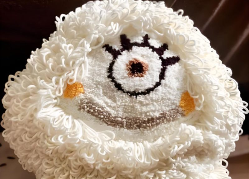 Close-up of plush toy face showing embroidery distortion on curly fabric