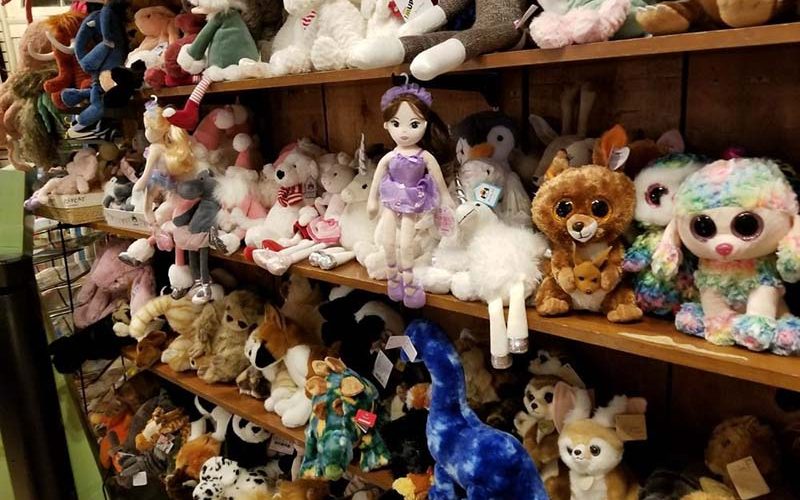 Shelves filled with assorted stuffed animals and plush dolls displayed in a toy shop
