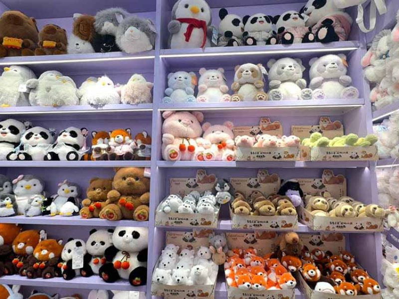 A showroom display featuring a wide variety of plush toys in different characters, sizes, and styles for retail selection.