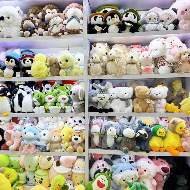 Shelves filled with assorted plush toys, including penguins, bears, rabbits, ducks, and character stuffed animals in a showroom.