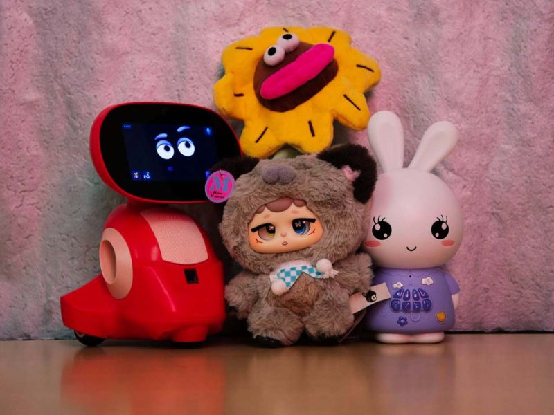 A group of toys including a smart robot toy, plush dolls, and a rabbit-shaped electronic toy, displayed together as modern children’s play companions combining technology and soft toys.