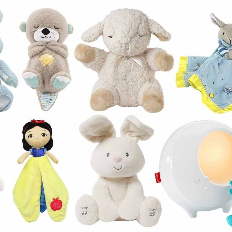 A collection of soft baby plush toys, including bears, bunnies, lambs, comfort blankets, character dolls, and a night-light plush, arranged together on a white background.
