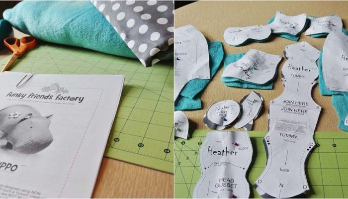 Printed plush toy sewing patterns laid out on fabric alongside scissors, tape, and materials for crafting a stuffed animal.