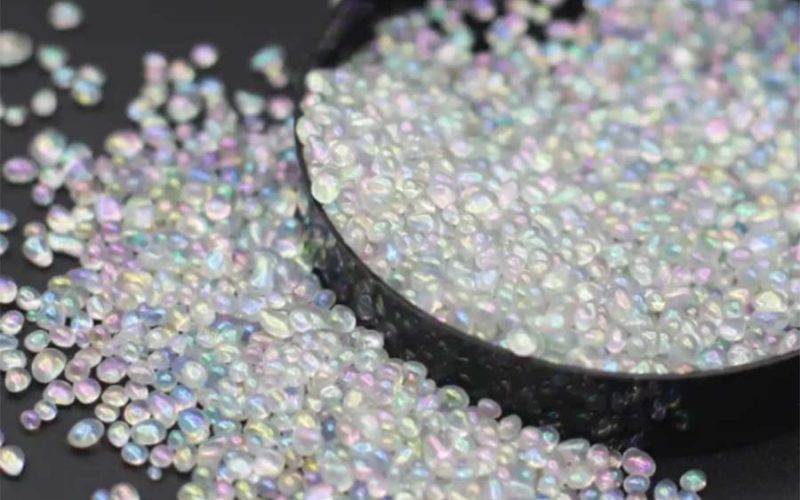 Close-up of iridescent poly pellets used as weighted stuffing material for plush toys and weighted stuffed animals.
