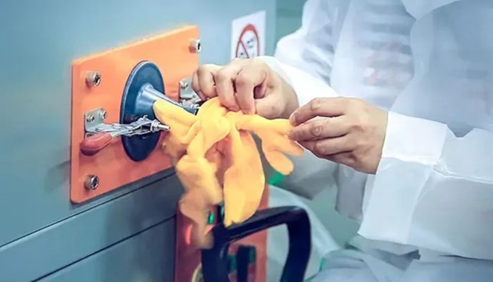 Worker using an automatic stuffing machine to fill a plush toy limb with fiber stuffing, demonstrating factory-level production in plush toy manufacturing.