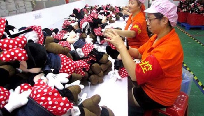 Factory workers inspecting and sorting Minnie Mouse plush toys on a production line in China.