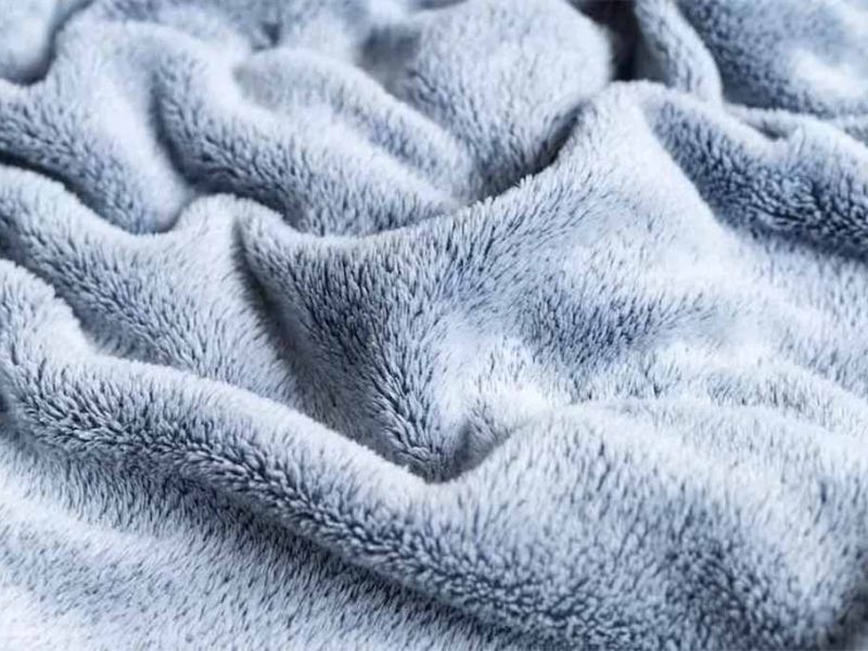 Close-up of light gray velboa fabric with smooth, short fibers, ideal for plush toys, cushions, and decorative soft goods.