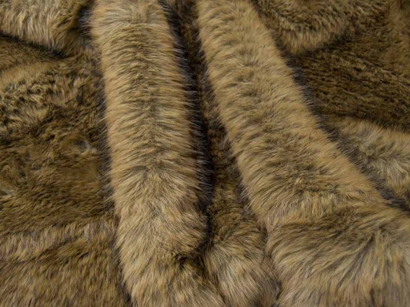 Close-up of soft brown faux fur fabric with realistic long-pile texture, used for plush toys, costumes, and luxury decorative items.
