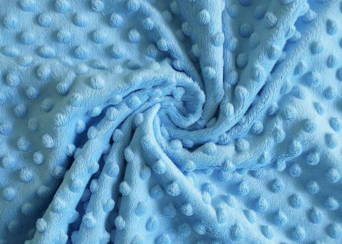 Soft blue minky plush fabric with raised dot texture, commonly used for baby toys and stuffed animals.